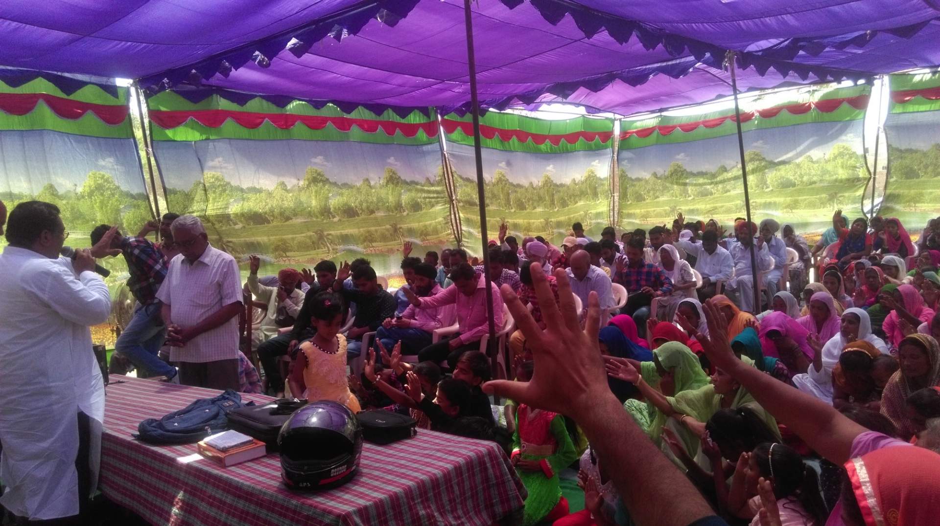 Pastor Singh's growing congregation meets in a tent while waiting for completion of the larger church.