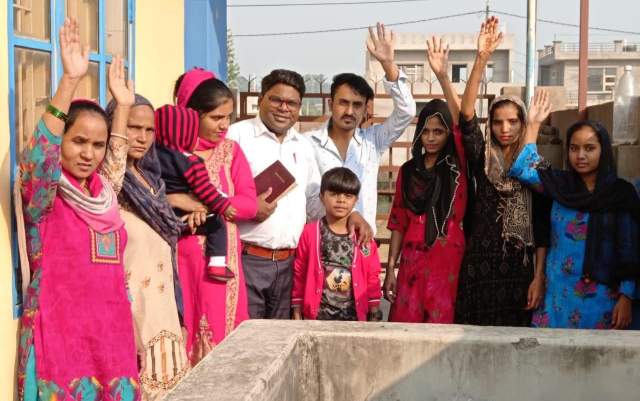 Before the baptism. Pastor Sanjeev with son, Enoch, his wife, Neru, at his side, holding daughter Rayna.