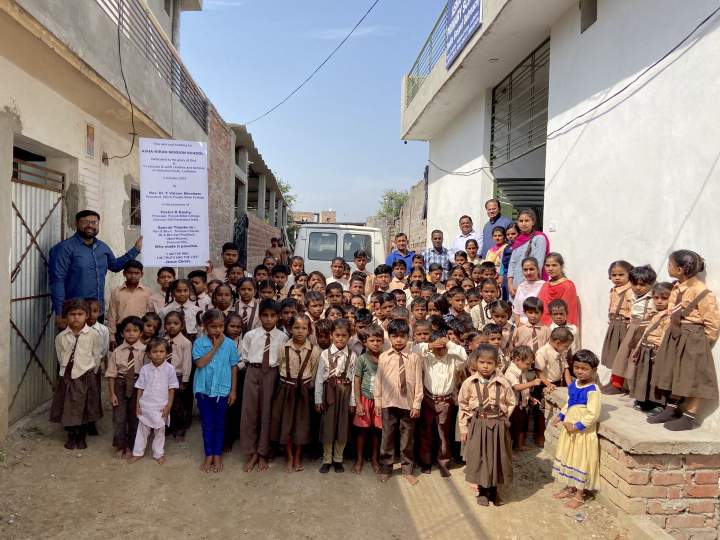 Children and teachers in front of the new school building.