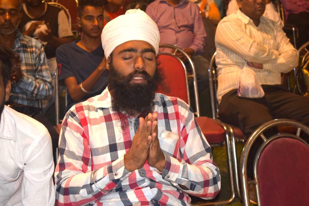 A man prays at an evangelistic outreach in Punjab.